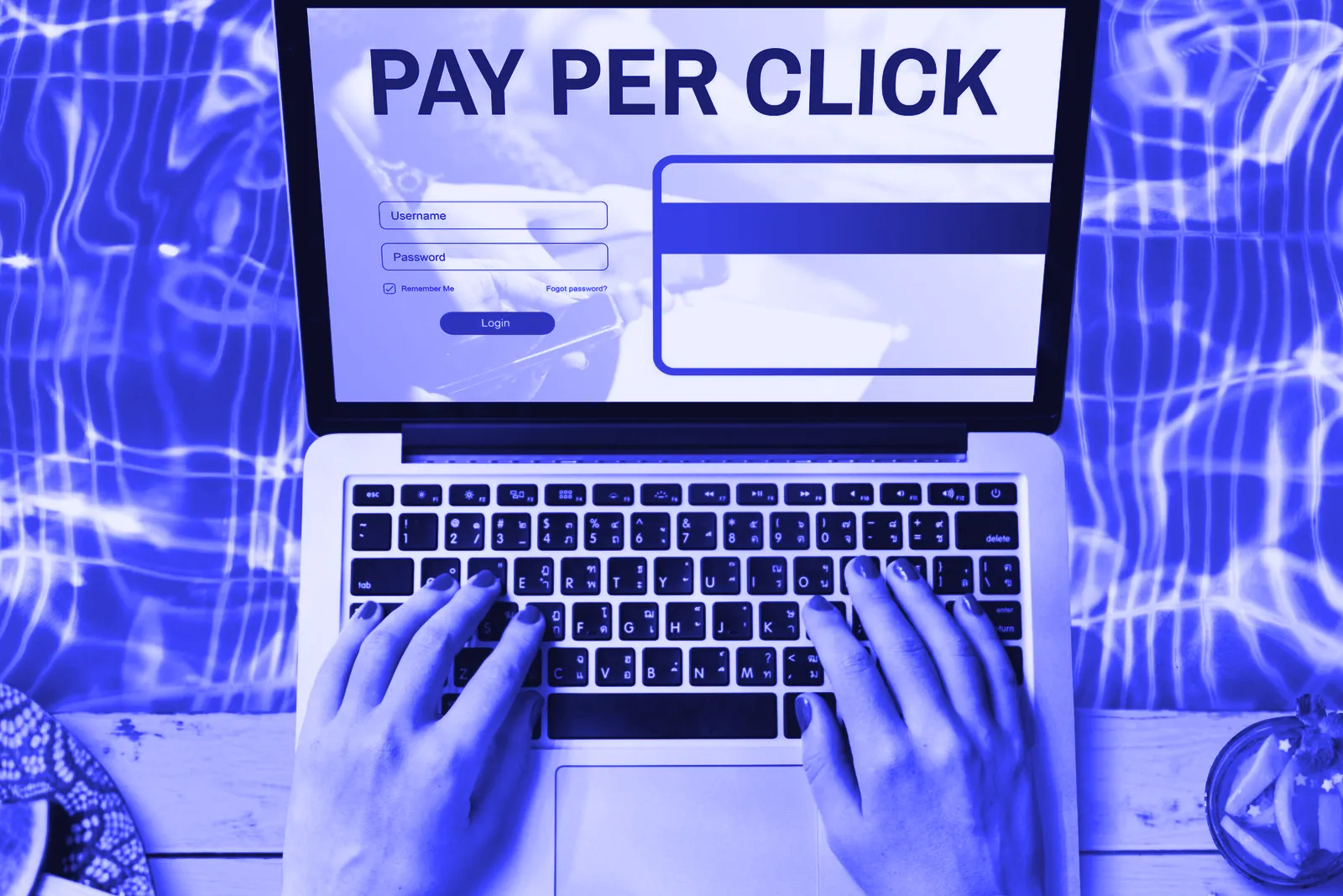 Hands typing on a laptop showing a pay-per-click screen